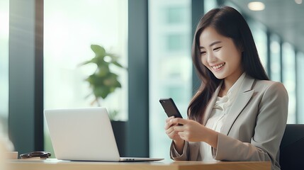 Wall Mural - Young professional Asian business woman worker holding cellphone using mobile thinking on new cell phone tech solution feeling happy sitting at desk in office working. generative AI