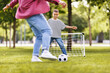 © JenkoAtaman - Happy ethnic family father and son playing football in the park in summer
