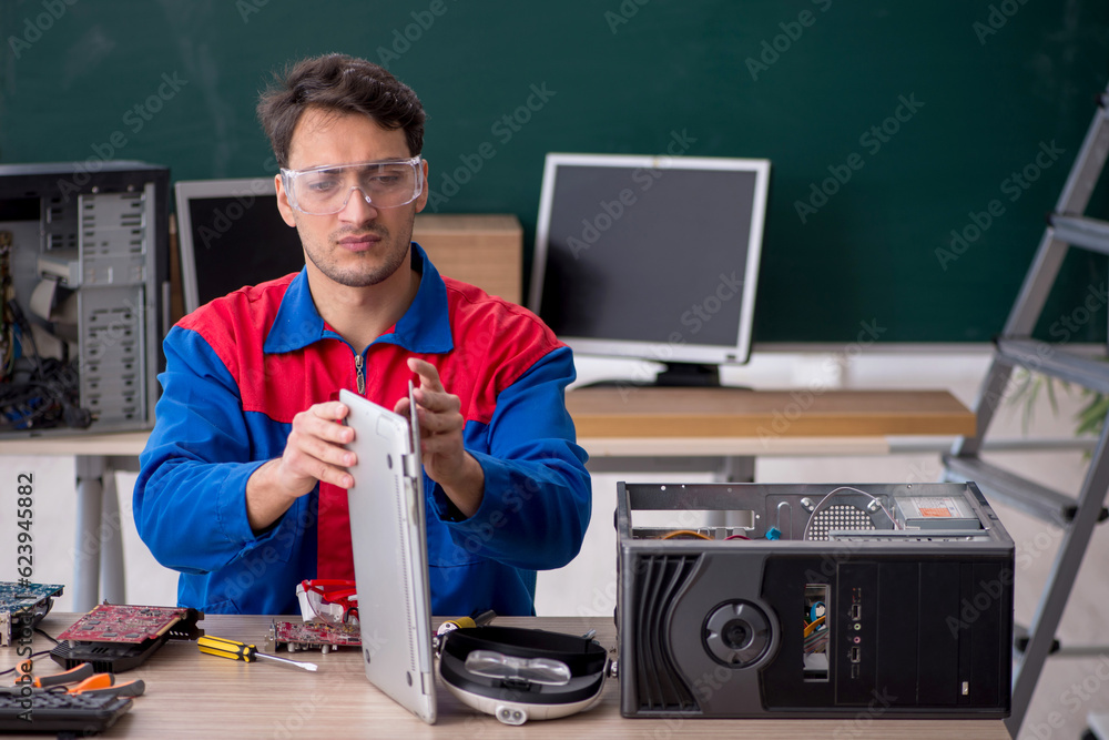 Men Repairing Computer Young male repairman repairing computers in the classroom Stock Photo ...