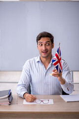 Wall Mural - Young male english language teacher in the classroom