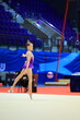 girl gymnast performs an exercise with a ball