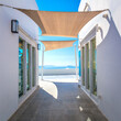 Greece, Santorini island, Oia - white architecture of a narrow street with awnings for shade. Greek Islands, Santorini