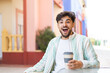 Handsome Arab man holding a take away coffee at outdoors with surprise and shocked facial expression