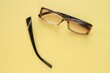 © Lidia - Old broken eyeglasses with damaged legs on yellow background. Poor eyesight. Reuse and repair concept. Idea of health. Failure optic eyewear. Breakage of vision correction glasses. Close up, flat lay