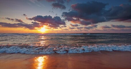 Wall Mural - colorful ocean beach sunrise with color sky and sunrays and rolling waves on the sea shore 4k video