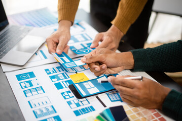 UI designer and UX developer team designer brainstorming about mobile app interface wireframe design with customer breif and color code at modern office..