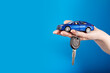 © yta - Buying a car, Motor vehicle rent, Lease or purchase, car and car keys in hand on a blue background, copy space