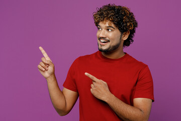 Wall Mural - Full body young Indian man he wearing red t-shirt casual clothes point index finger aside indicate on workspace area copy space mock up isolated on plain purple background studio. Lifestyle concept.