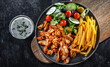 Kebab served with french fries, vegetable salad and tzatziki