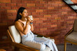 Latin woman relaxing while drinking at the coffee shop