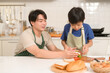 © tonefotografia - Happy Young Asian father and son eating healthy food in kitchen at home
