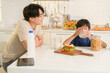 © tonefotografia - Happy Young Asian father and son eating healthy food in kitchen at home