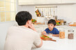 © tonefotografia - Happy Young Asian father and son eating healthy food in kitchen at home