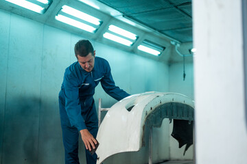 Wall Mural - Caucasian man is cleaning car parts before spraying color in repair mechanic painting shop