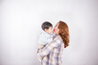 © artrolopzimages - Beautiful photo of mom holding baby on light background in photo studio. Family and baby concept.