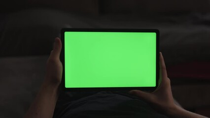 Wall Mural - Man at home lying on a couch with tablet pc with green screen