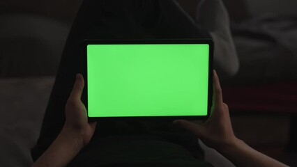 Wall Mural - Man at home lying on a couch with tablet pc with green screen