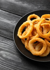 Wall Mural - Crunchy Fried Battered onion rings on black plate