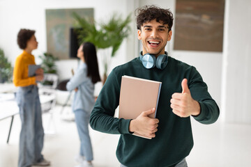 Excited european male student showing thumbs up and smiling, recommending educational courses