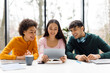 © Prostock-studio - Group of diverse smart university students sitting in classroom discussing and working on project together, using tablet