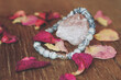 jaspis zebra gem stone bracelet with rose quartz and rose petals on a wooden table