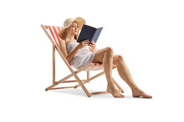 Poster - Beautiful young woman in a white dress sitting on a beach chair and reading a book