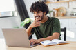 © kucherav - Smiling Asian man student using laptop computer watching the webinar or seminar. Online education, e-learning concept
