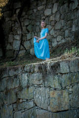 Sticker - A woman in a blue dress stands in the ruins of a medieval fortress.