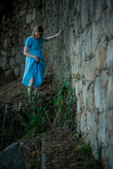 Sticker - A woman dressed in blue makes her way through ancient ruins.