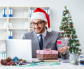 Wall Mural - Young businessman celebrating christmas in the office