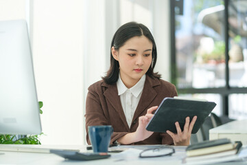 Wall Mural - Charming young startup businesswoman using digital tablet, planning a project in office