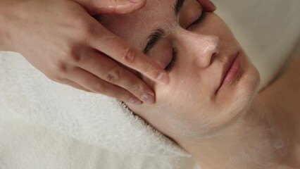 Wall Mural - Young caucasian woman confident having facial treatment at beauty center. Facial massage beauty treatment.