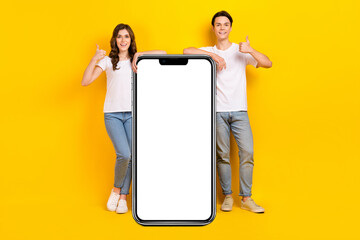 Poster - Full length photo of confident cute husband wife dressed white t-shirts thumbs up device empty space isolated yellow color background