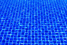 The Blue Tiles Floor Under The Clear Water In The Swimming Pool Background, Swimming Pool Surface With Floor Mosaic Tiles In Blue