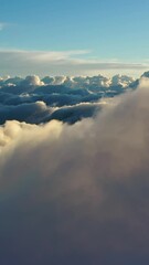 Wall Mural - flying above the clouds. aerial view of clouds at sunrise. traveling by air perfect background. vert