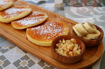 Wall Mural - Closeup of chopped nuts with sliced bananas, healthy toppings of pancaked