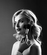 © Yevhen - Hand of visagiste, painting cosmetics beauty model girl. Make up in process. Applying tone to skin. Beautiful woman face. Black and white