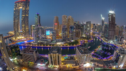 Wall Mural - Panoramic view of Dubai Marina with several boat and yachts parked in harbor and skyscrapers around canal aerial day to night timelapse.