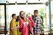 © master1305 - Happy, smiling, young woman in stylish clothes meeting with friends at cafe, having funny, joyful time. Blurred people on background. Friendship, meeting, party, communication, alcohol drinks concept