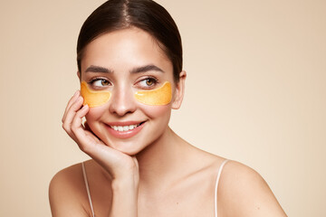 a young beautiful smiling woman with cosmetic patches on her eyes. cosmetic procedures skin care aro