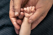 © puhimec - The handle of a newborn in the hands of a grandmother, close-up.