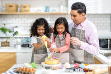 Portrait Of Enjoy Happy Love Asian Family Father And Little Toddler Asian Girl Daughter Child Having Fun Cooking Together With Dough For Homemade Bake Cookie And Cake Ingredient On Table In Kitchen