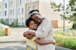 © Seventyfour - Portrait of African American mother embracing her son and smiling at camera while they standing outdoors