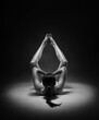 Beautiful nude sexy fitness girl with great figure flexing her perfect body in a yoga pose at the studio. Black and white photo