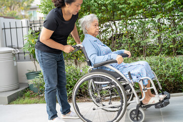 Caregiver help and care Asian senior woman patient sitting on wheelchair to ramp in nursing hospital, healthy strong medical concept.