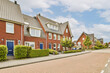 © Casa imágenes - an empty street in the netherlands with red brick houses on either side and blue sky overhead over them all around