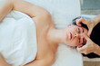 © ADDICTIVE STOCK - Young woman lying with back on bed during spa therapy