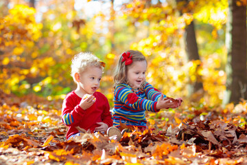 Wall Mural - Child in fall park. Kid with autumn leaves.