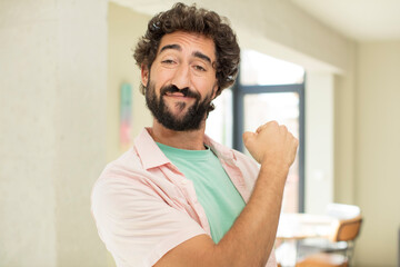 Wall Mural - young crazy bearded man feeling happy, positive and successful, money concept and celebrating good results