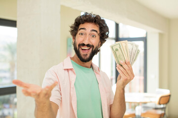 Wall Mural - crazy bearded man smiling happily and offering or showing a concept. dollar banknotes concept